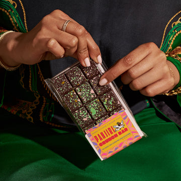 Person holding a box of Pantry Chocolates with a colorful label.