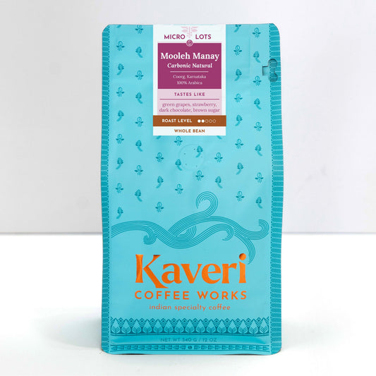 A package of Kaveri Coffee Works Mooleh Manay whole bean coffee in a bright turquoise blue bag with orange and white text, photographed against a clean white background.