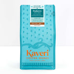 A package of Kaveri Coffee Works Peaberry whole bean coffee, featuring a bright turquoise blue bag with orange and white text and decorative patterns.