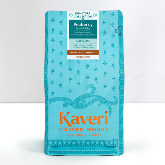 A package of Kaveri Coffee Works Peaberry whole bean coffee from the Signature Collection, in a light blue resealable pouch with orange and white text.